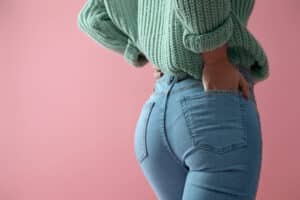 Woman with curvy buttocks in jeans after getting a brazilian butt lift