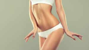Woman showing a contoured midsection, representing body contouring results from combined plastic surgery procedures.