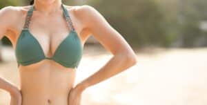 Woman in swimwear showing enhanced breast shape and fullness after breast augmentation.