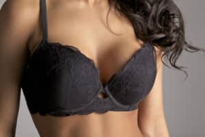 Woman wearing a black bra, illustrating breast shape, volume, and projection when considering breast implant size and profile.