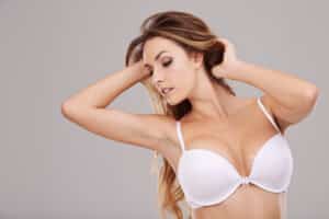 Woman wearing a white bra, illustrating breast shape and appearance for a blog about prepectoral breast reconstruction.